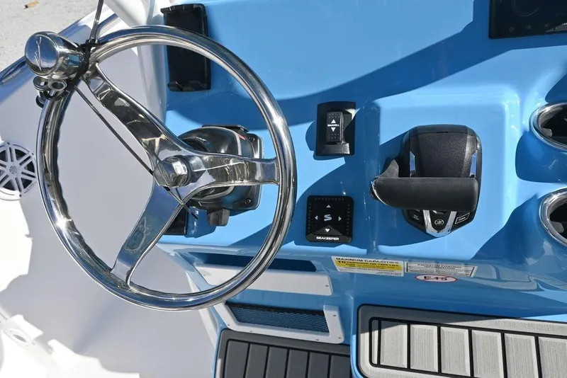 Slide: The Image of Steering console of 2026 Tidewater 232 CC Adventure boat with chrome wheel and controls. - 13
