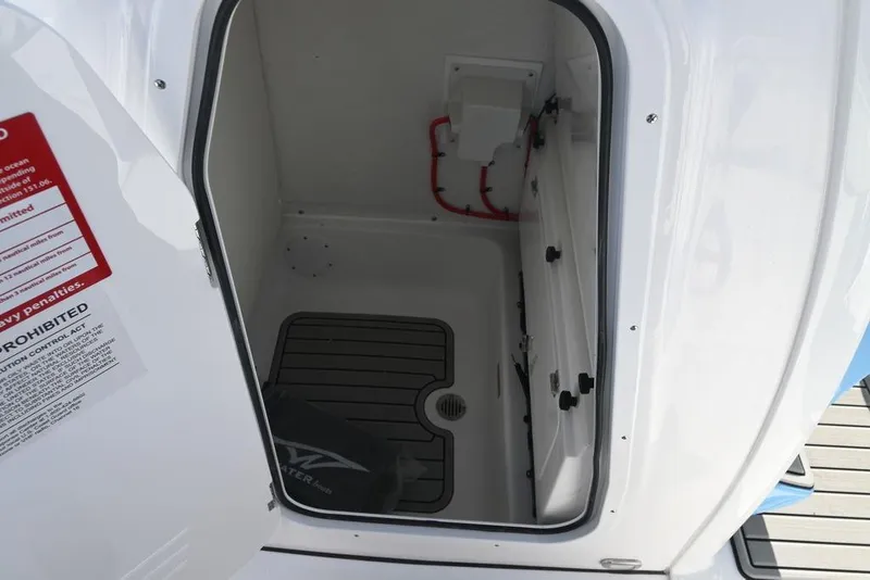 Slide: The Image of 2026 Tidewater 232 CC Adventure boat storage compartment with open door and visible interior. - 21