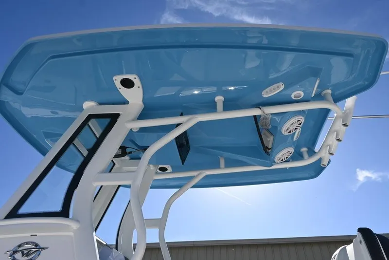 Slide: The Image of 2026 Tidewater 232 CC Adventure boat with blue T-top and speakers, under clear sky. - 5
