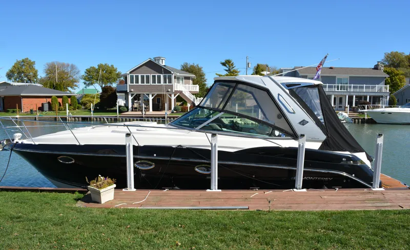 Slide: The Image of 2013 Monterey 340 Sport Yacht docked by waterfront homes. - 2