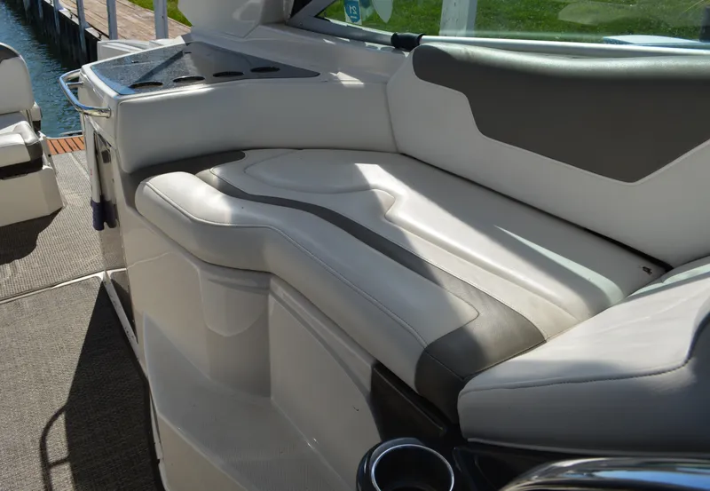Slide: The Image of 2013 Monterey 340 Sport Yacht interior with white and gray seating, docked by the water. - 25