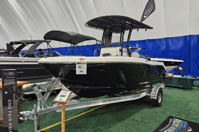 The Image of 2025 Robalo R180 Center Console boat displayed indoors on a trailer. - 0