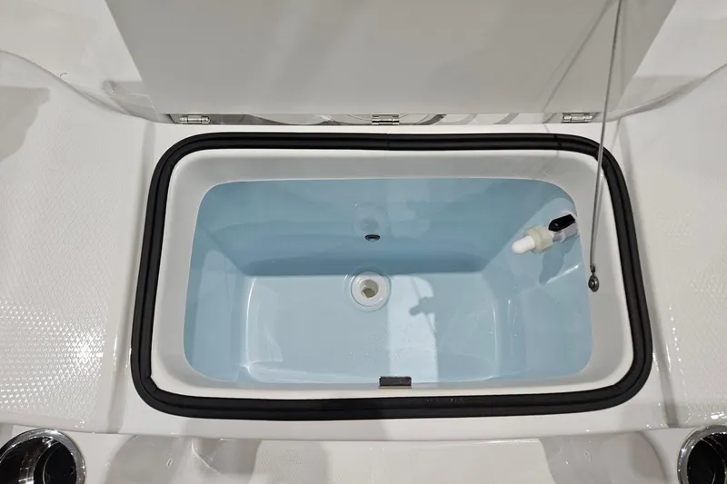 Slide: The Image of 2025 Robalo R180 Center Console livewell, open lid, white interior, marine equipment. - 11