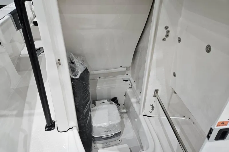Slide: The Image of 2025 Robalo R180 Center Console interior storage compartment with portable toilet. - 12
