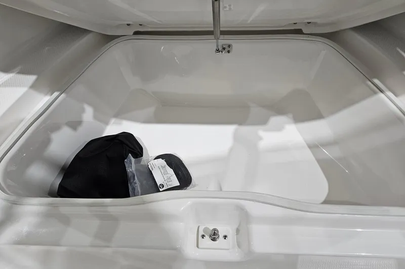 Slide: The Image of 2025 Robalo R180 Center Console storage compartment with black bag and label inside. - 21