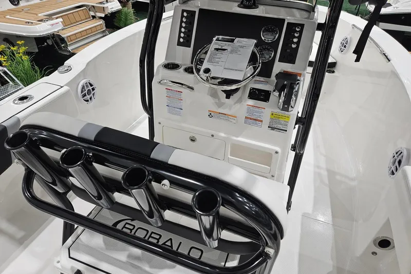 Slide: The Image of 2025 Robalo R180 Center Console boat interior with steering wheel and rod holders. - 5