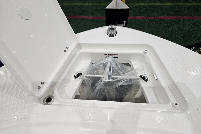 Slide: The Image of 2025 Robalo R180 Center Console anchor storage compartment open on deck. - 6