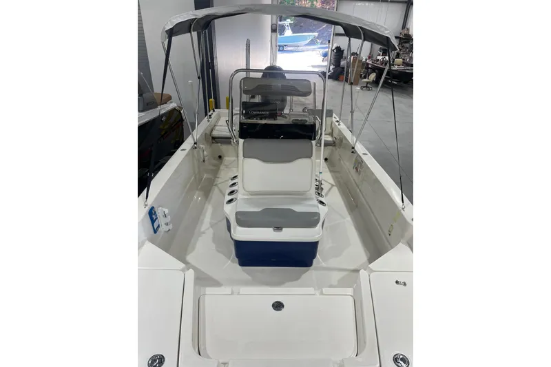 Slide: The Image of 2015 Skeeter SX2250 boat interior with canopy, seating, and control panel in a garage setting. - 18