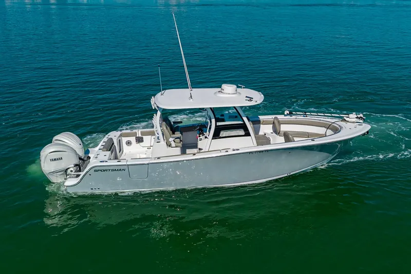 Slide: The Image of 2023 Sportsman Open 302 Center Console boat cruising on clear blue water. - 16