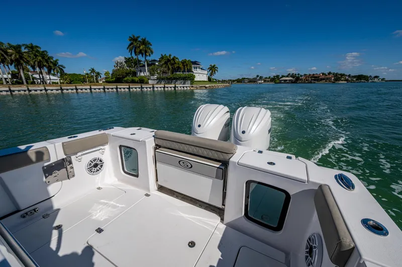 Slide: The Image of 2023 Sportsman Open 302 Center Console boat cruising on a sunny day, featuring dual engines. - 21