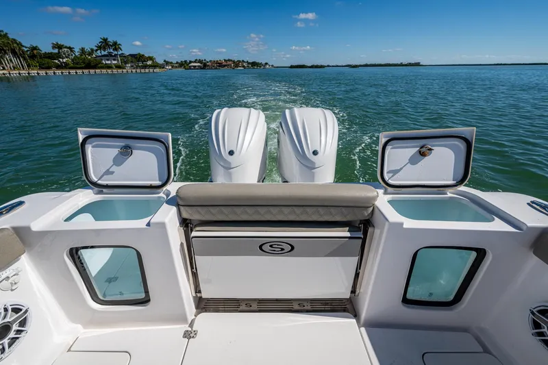 Slide: The Image of 2023 Sportsman Open 302 Center Console boat with dual engines on a sunny day. - 23