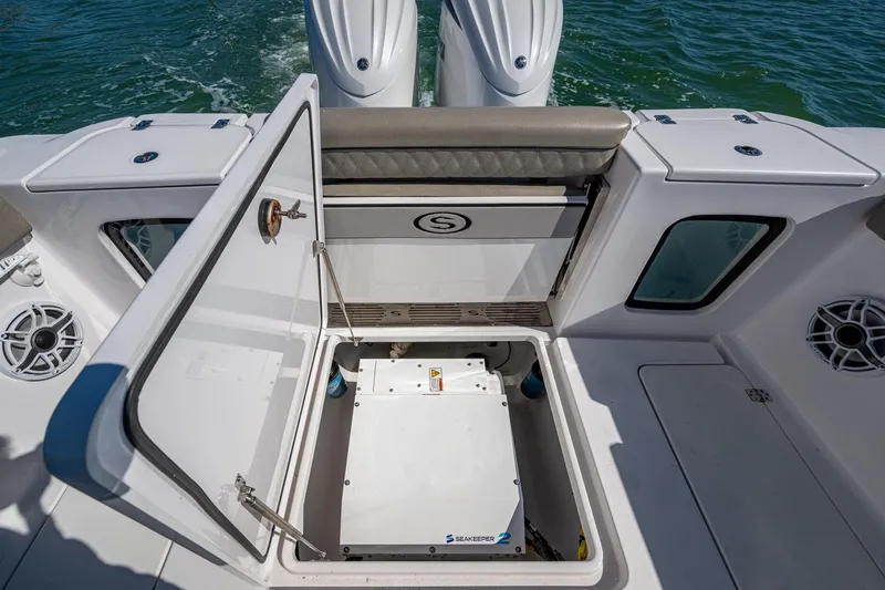 Slide: The Image of 2023 Sportsman Open 302 Center Console boat with open storage compartment and twin engines. - 24
