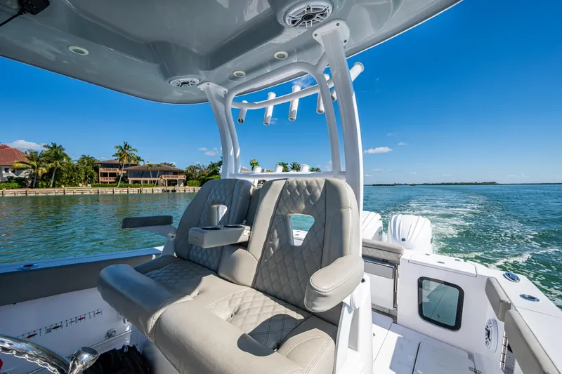 Slide: The Image of 2023 Sportsman Open 302 Center Console boat interior on sunny day, coastal view. - 33
