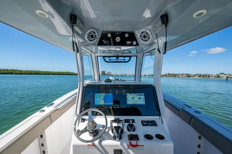 Slide: The Image of 2023 Sportsman Open 302 Center Console boat interior with steering wheel and navigation system. - 35