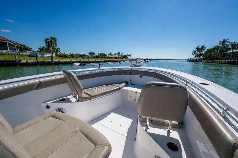 Slide: The Image of 2023 Sportsman Open 302 Center Console boat interior with seating, on a sunny waterway. - 38