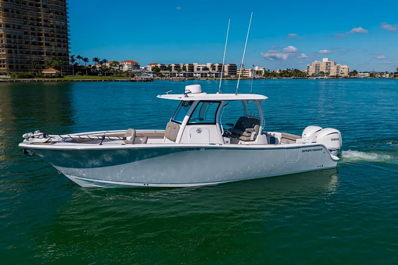 Slide: The Image of 2023 Sportsman Open 302 Center Console boat cruising on clear blue water. - 4