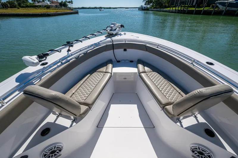 Slide: The Image of 2023 Sportsman Open 302 Center Console boat interior with luxurious seating on calm water. - 40