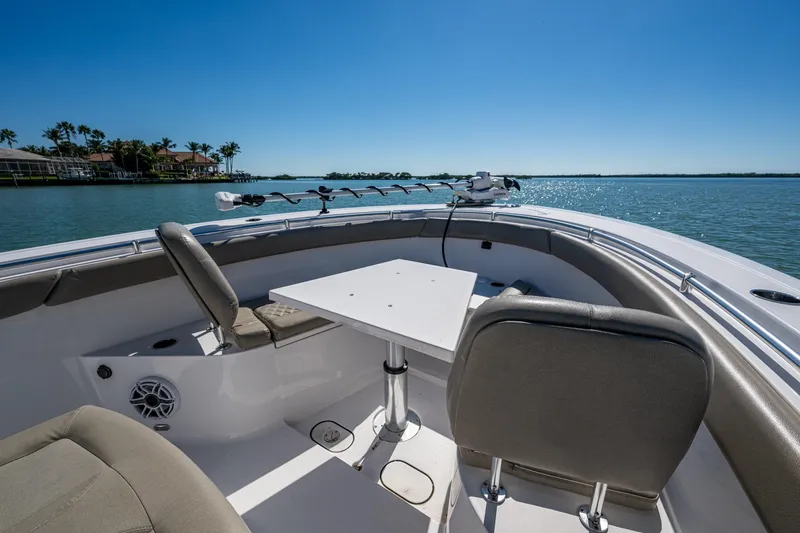 Slide: The Image of 2023 Sportsman Open 302 Center Console boat interior with seating and table on a sunny day. - 41