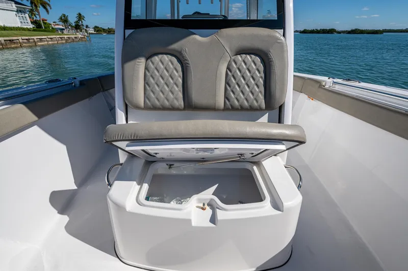 Slide: The Image of 2023 Sportsman Open 302 Center Console boat with cushioned seating and storage compartment. - 42