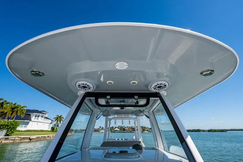 Slide: The Image of 2023 Sportsman Open 302 Center Console boat with sleek T-top design on a sunny day. - 44