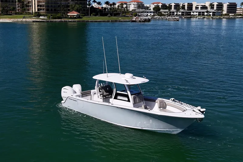 Slide: The Image of 2023 Sportsman Open 302 Center Console boat on calm water near coastal buildings. - 49