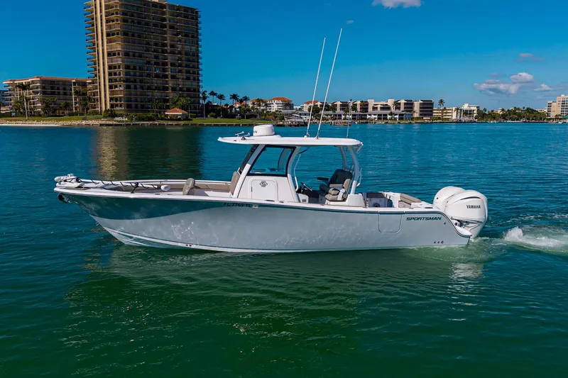 Slide: The Image of 2023 Sportsman Open 302 Center Console boat cruising on clear blue water. - 5