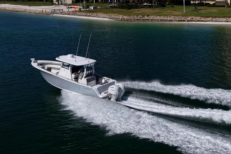 Slide: The Image of 2023 Sportsman Open 302 Center Console boat cruising on clear blue water. - 52