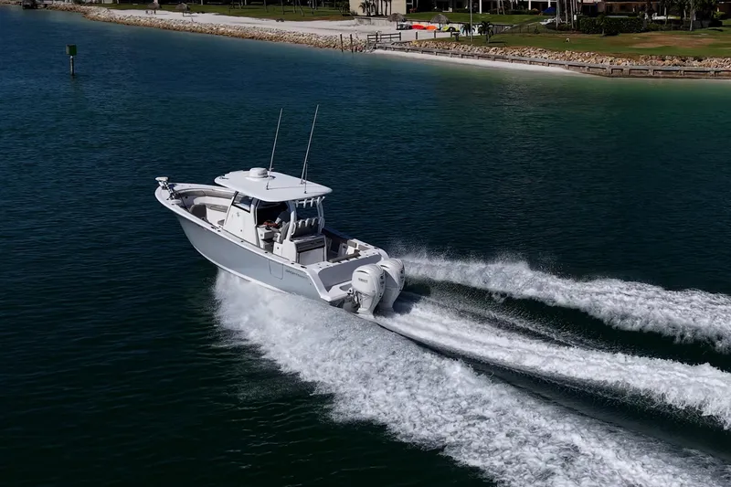 Slide: The Image of 2023 Sportsman Open 302 Center Console boat cruising on clear blue water. - 53