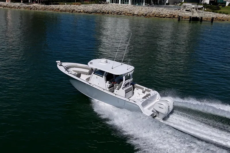Slide: The Image of 2023 Sportsman Open 302 Center Console boat cruising on calm water. - 56