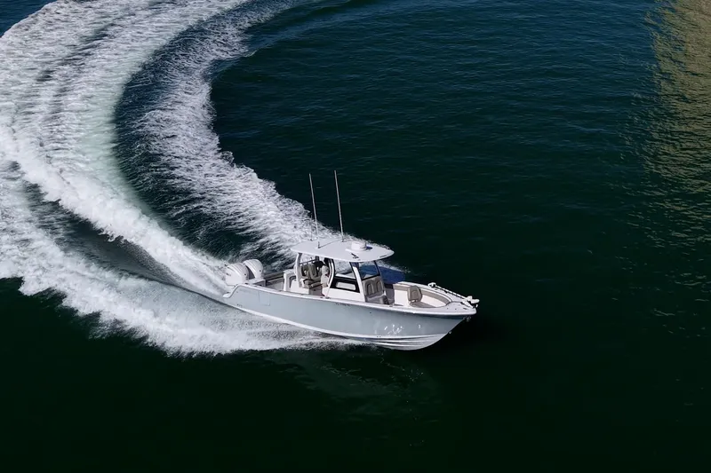 Slide: The Image of 2023 Sportsman Open 302 Center Console boat making a sharp turn on open water. - 65