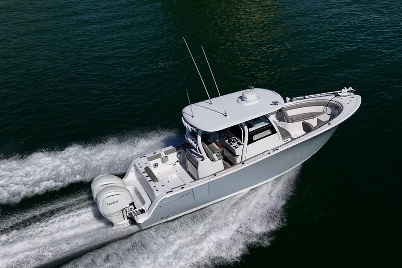 Slide: The Image of 2023 Sportsman Open 302 Center Console boat cruising on water, aerial view. - 71