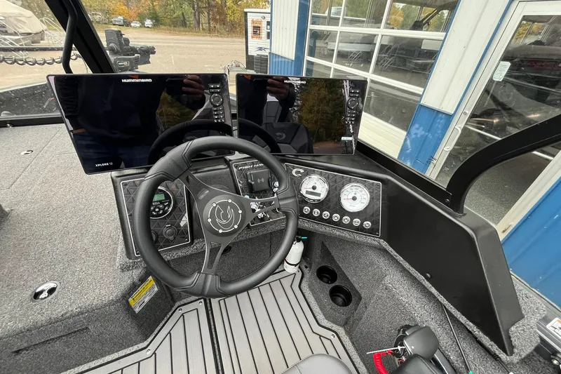 Slide: The Image of 2025 Crestliner 2050 Fish Hawk boat dashboard with steering wheel and electronic displays. - 10