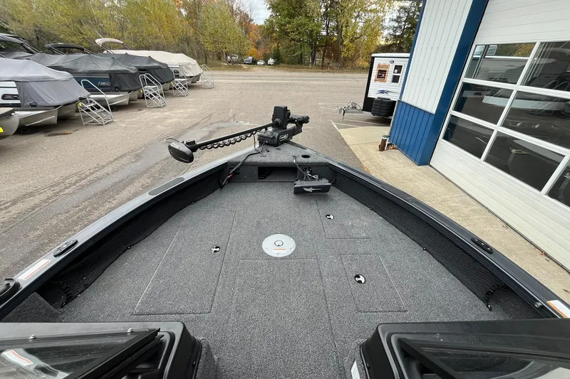 Slide: The Image of 2025 Crestliner 2050 Fish Hawk boat, docked with covered boats in the background. - 11