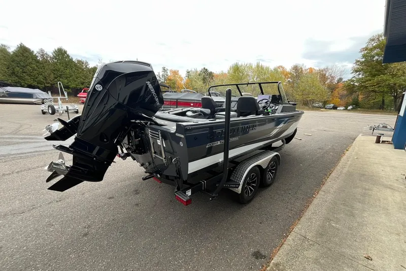 Slide: The Image of 2025 Crestliner 2050 Fish Hawk boat on trailer, parked outdoors, showcasing powerful outboard motor. - 3