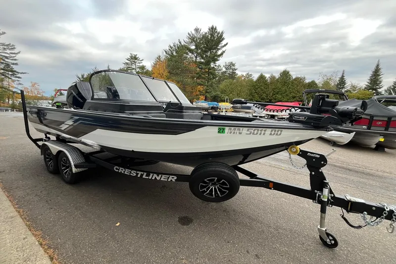 Slide: The Image of 2025 Crestliner 2050 Fish Hawk boat on trailer, parked outdoors with trees in background. - 4