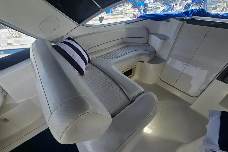 Slide: The Image of Interior of 2005 Bayliner 2855 Ciera boat with white seating and striped pillow. - 13