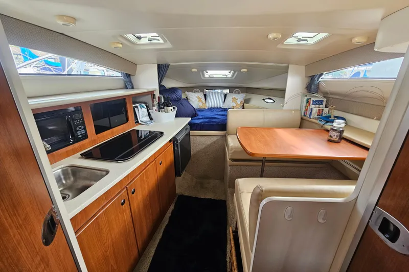Slide: The Image of 2005 Bayliner 2855 Ciera interior with kitchenette, dining area, and cozy sleeping quarters. - 21
