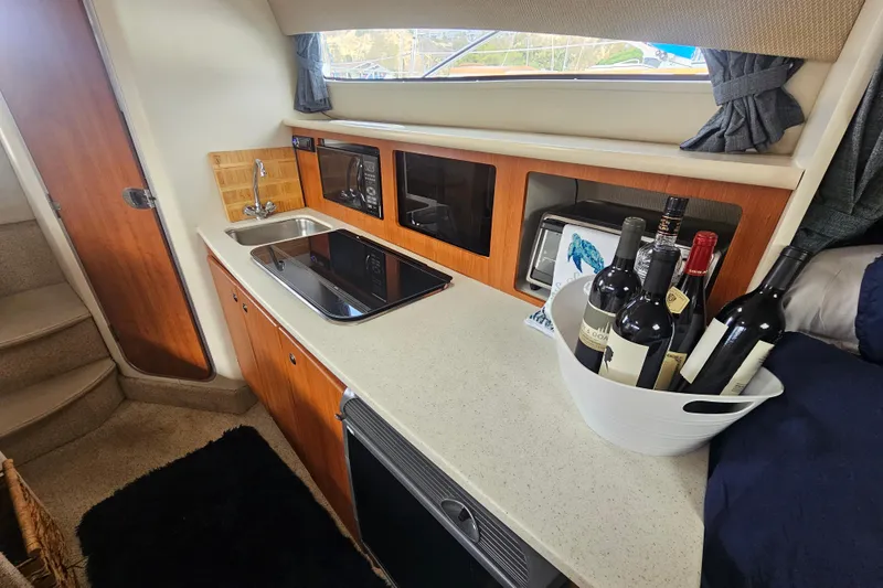 Slide: The Image of 2005 Bayliner 2855 Ciera boat interior with kitchenette, sink, and wine bottles. - 25