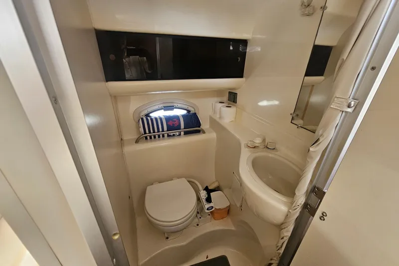 Slide: The Image of 2005 Bayliner 2855 Ciera boat bathroom with toilet, sink, and porthole window. - 32