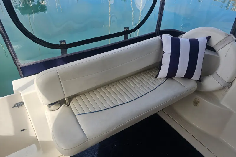Slide: The Image of 2005 Bayliner 2855 Ciera boat interior with cushioned seating and striped pillow. - 9