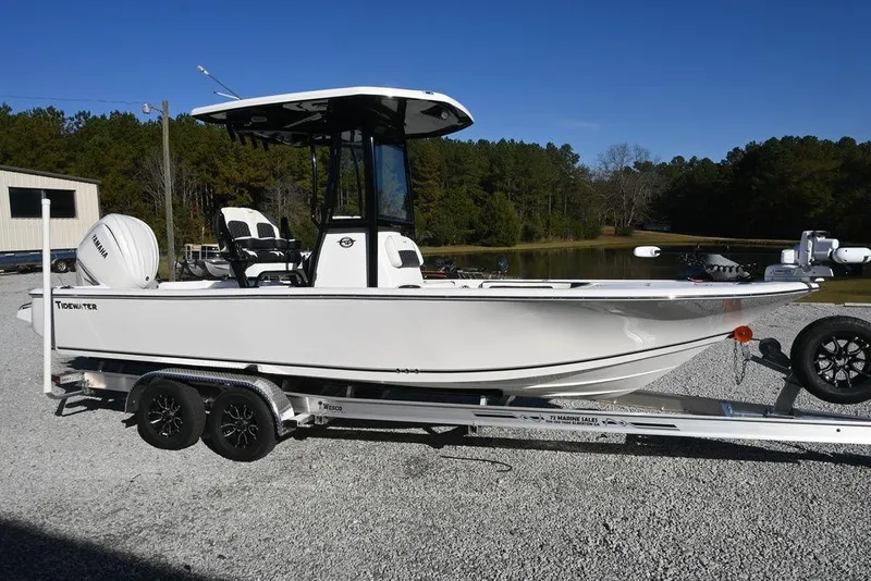 The Image of 2026 Tidewater 2300 Carolina Bay boat on trailer, parked outdoors under clear blue sky. - 1