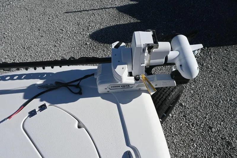 Slide: The Image of Tidewater 2300 Carolina Bay 2026 boat with Minn Kota trolling motor on gravel. - 13