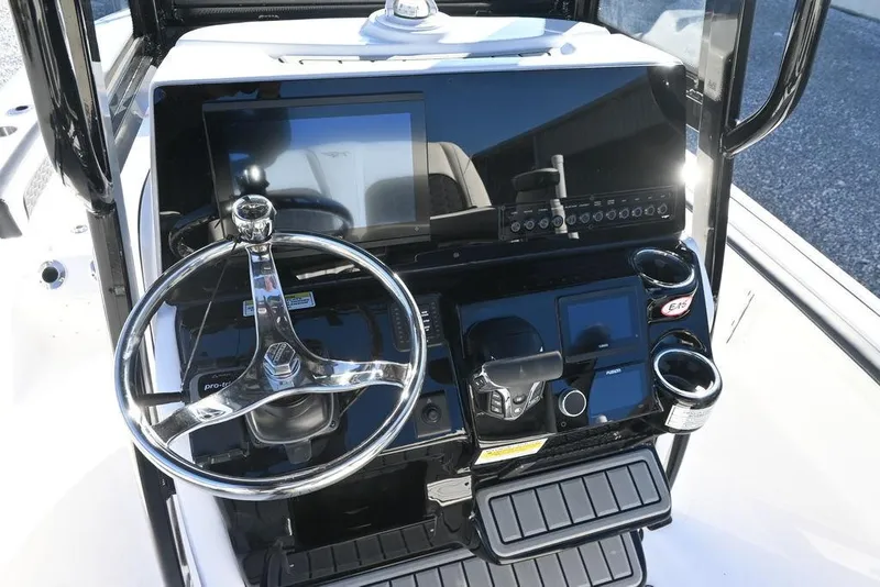 Slide: The Image of 2026 Tidewater 2300 Carolina Bay boat console with steering wheel and electronic controls. - 16