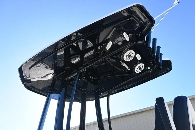 Slide: The Image of 2026 Tidewater 2300 Carolina Bay boat T-top with speakers, viewed from below against blue sky. - 3