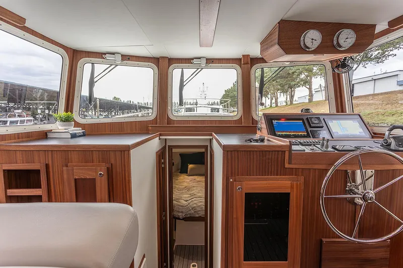 Slide: The Image of Interior of 2026 American Tug 362, featuring helm, navigation equipment, and cozy cabin entrance. - 9