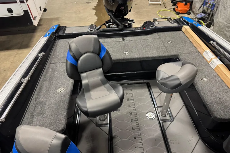 Slide: The Image of 2026 Nitro ZV20 Pro boat interior with gray and blue seating, fishing deck, and storage compartments. - 13