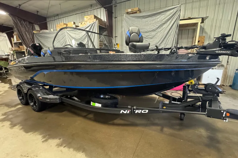 Slide: The Image of 2026 Nitro ZV20 Pro boat in a garage, featuring a sleek design and Garmin equipment. - 2