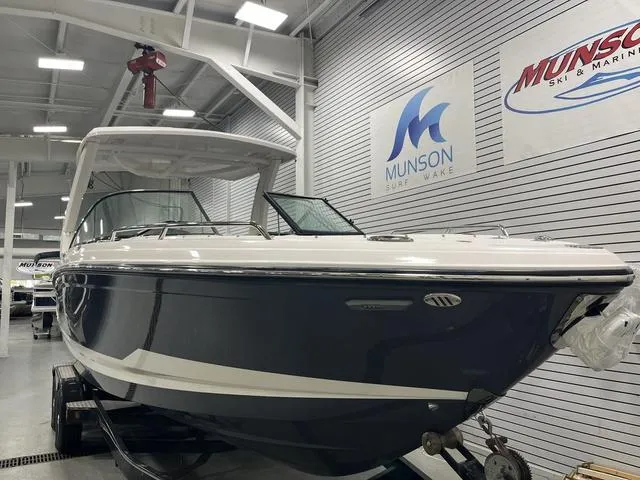 Slide: The Image of 2025 Chaparral 30 Surf boat displayed indoors at Munson Ski & Marine showroom. - 2