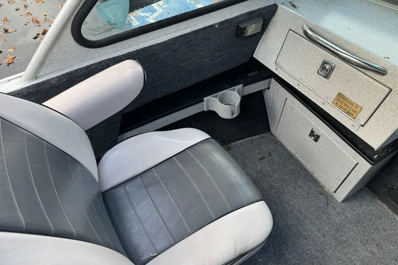 Slide: The Image of Interior of a 1994 Jetcraft Yukon boat with gray seating and storage compartments. - 15