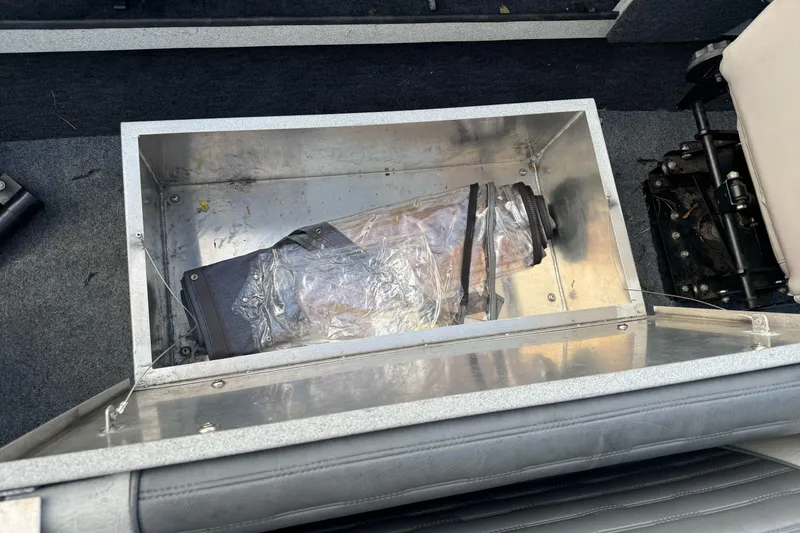 Slide: The Image of Storage compartment in a 1994 Jetcraft Yukon boat, containing a plastic-wrapped item. - 20